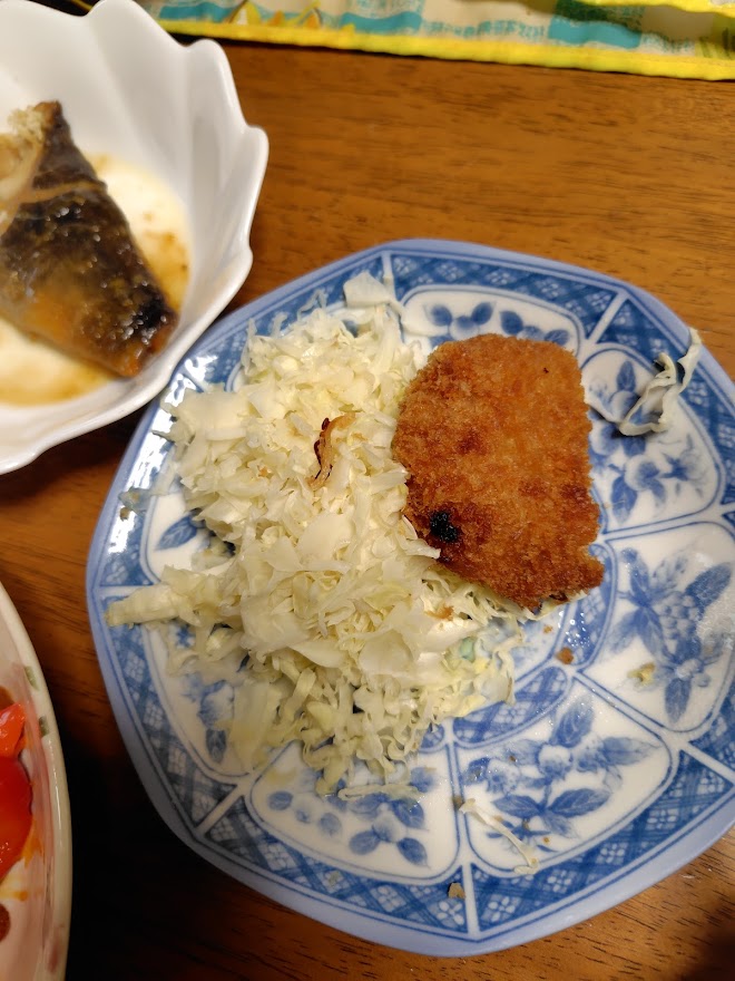 昨日の残りのコロッケとキャベツ。左上の魚はお母さまのおかず