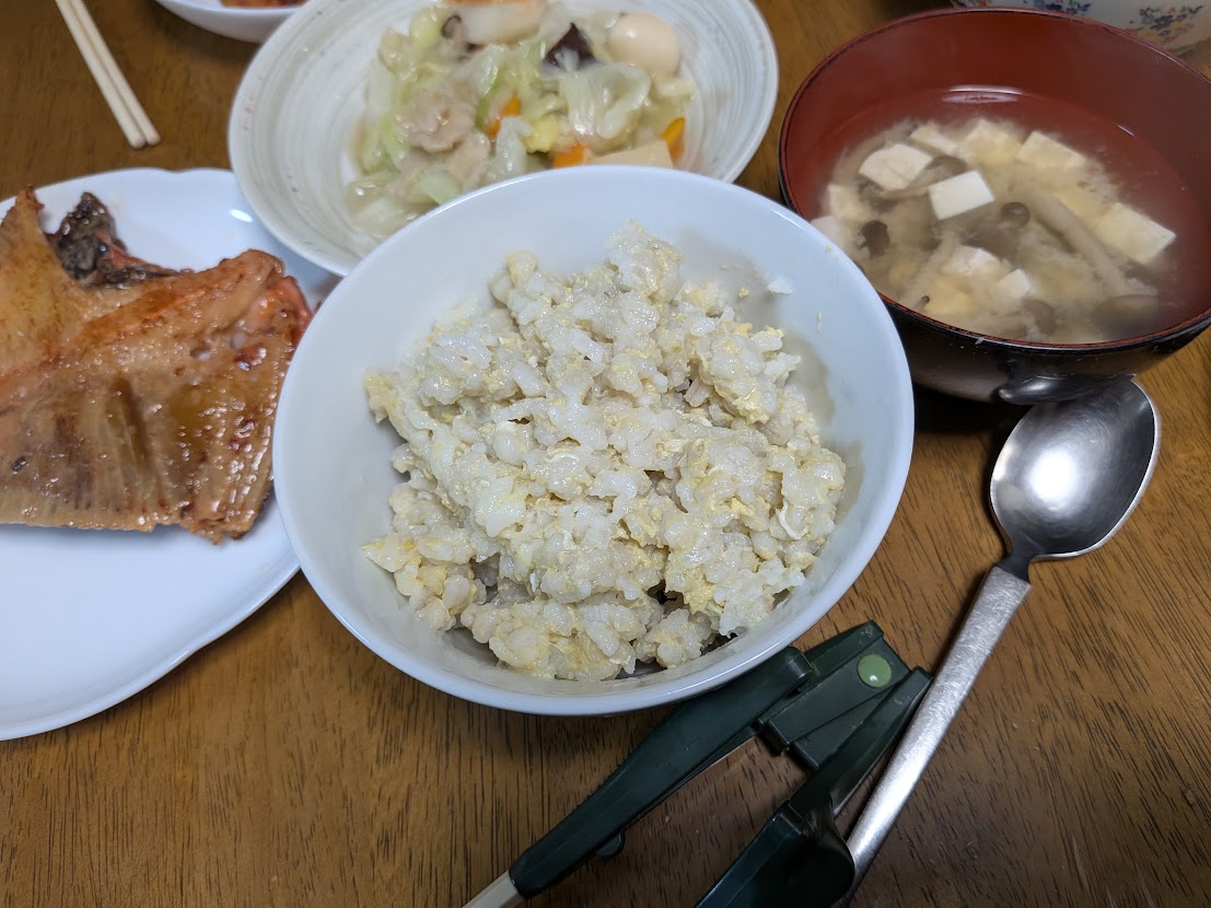 ご飯、魚、汁物などが並ぶ食卓