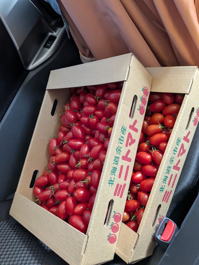 車の座席に置かれたミニトマトの箱